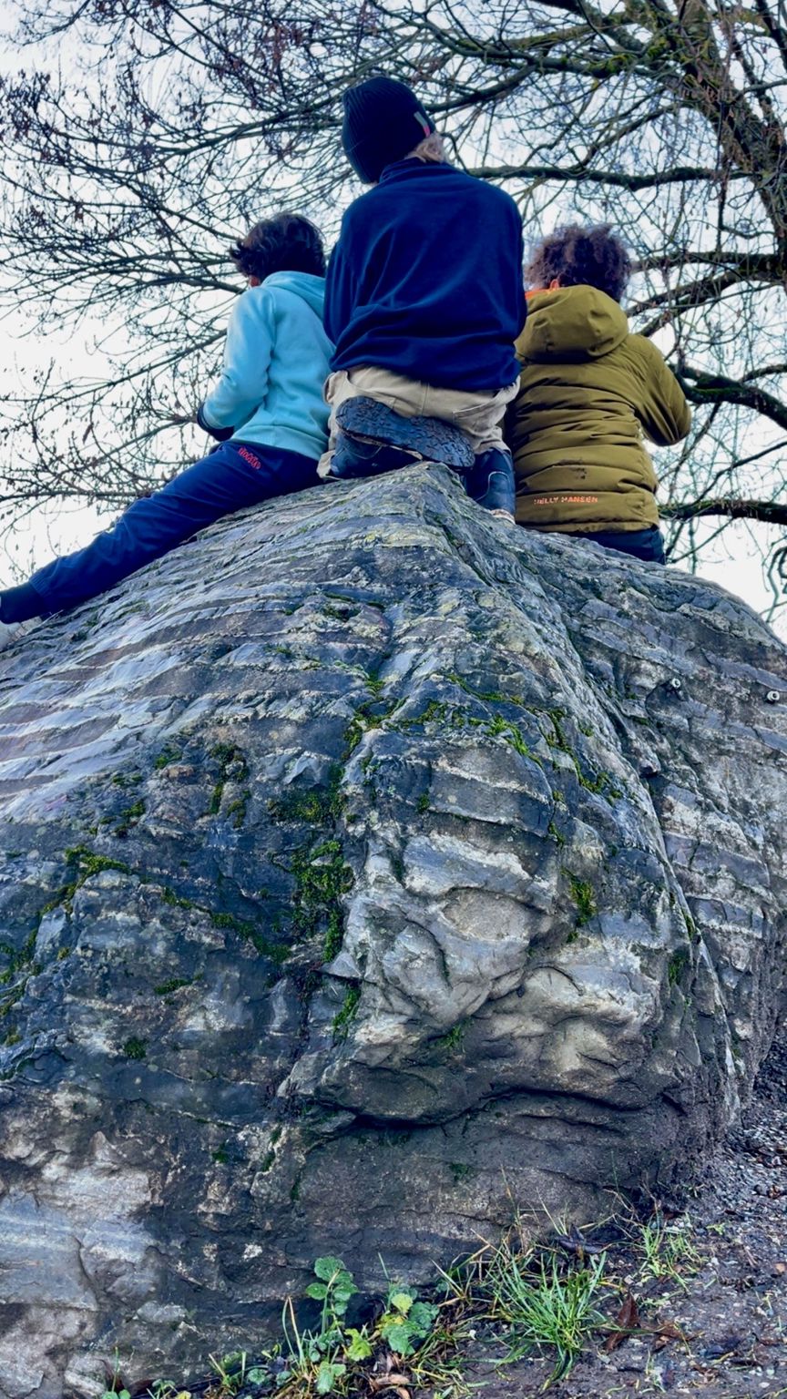 en gruppe mennesker som sitter på en stein en gruppe mennesker som sitter på en stein