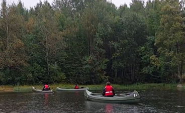 En gruppe mennesker i kanoer på en elv