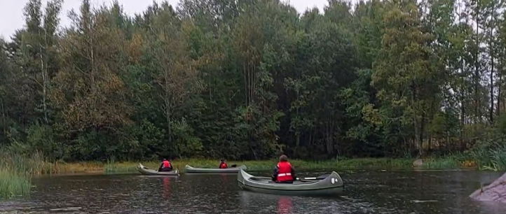 En gruppe mennesker i kanoer på en elv