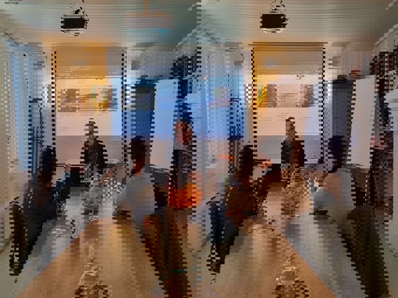 en gruppe mennesker som sitter rundt et bord og ser på en skjerm