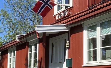 En rød bygning med flagg på taket