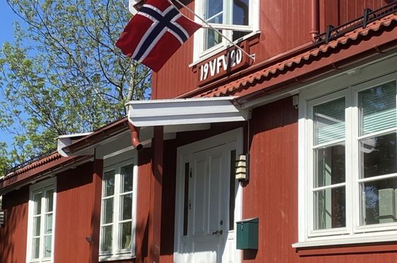 En rød bygning med flagg på taket