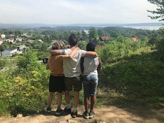 en gruppe mennesker som står på en høyde med utsikt over en by